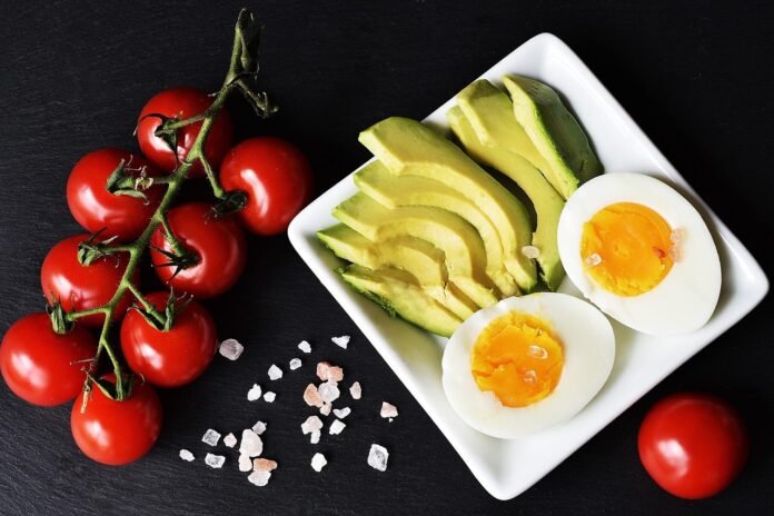 um prato de dieta cetogênica com ovos, abacate e tomates.
