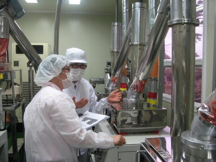 profissionais paramentados para preparo de alimentos.