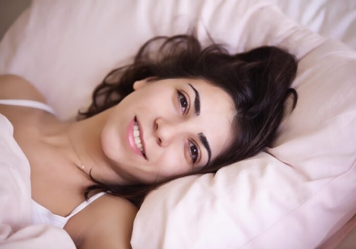 uma linda morena acordando de um sono reparador.