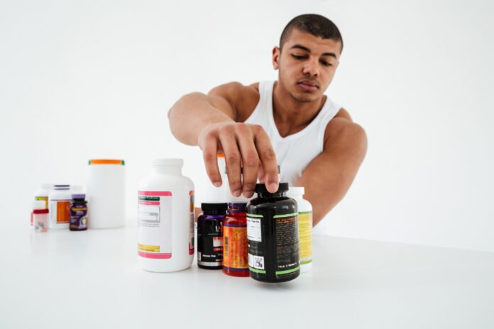 Um atleta apresentando seus suplementos sobre uma mesa.