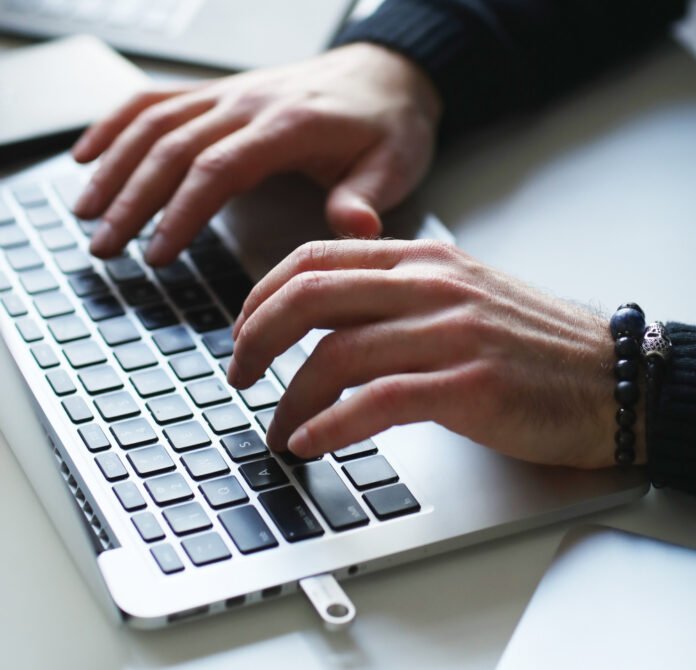 mãos digitando em um teclado.