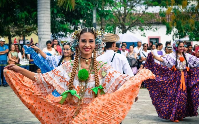 Jovem dançando numa praça com trajes típicos.