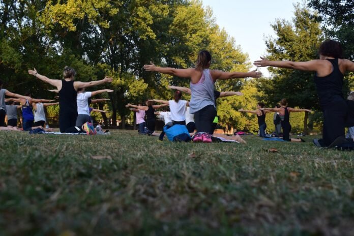 Um grupo de pessoas praticando yoga ao ar livre.
