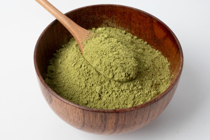 Tigela de madeira contendo moringa em pó.