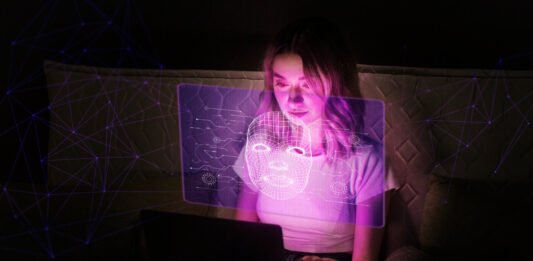 uma mulher acessando um computador num ambiente escuro.