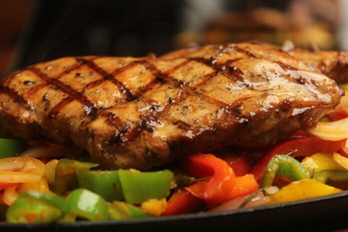 prato de filé de frango grelhado com legumes.