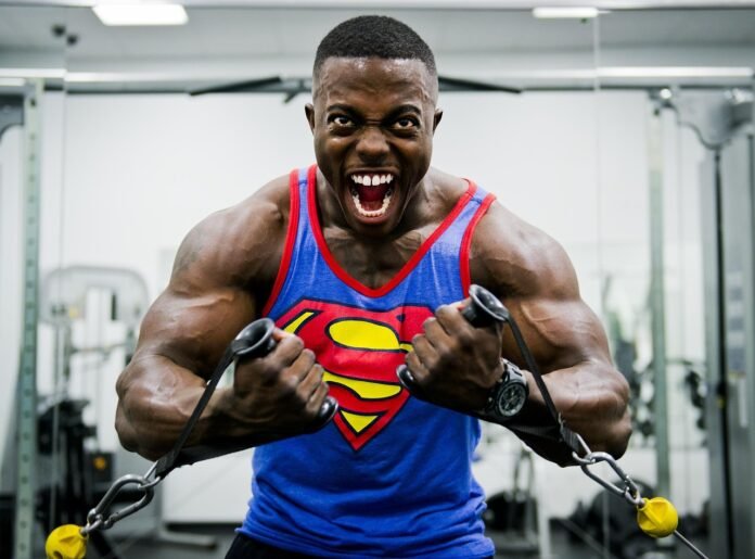 arte de um atleta negro muito musculoso, com uma camiseta do super-homem, fazendo exercicios de braços.