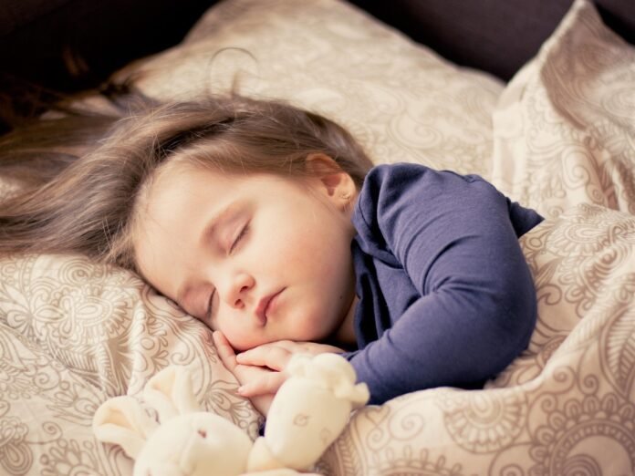 Um Bebe dormindo tranquilamente sob cobertores.