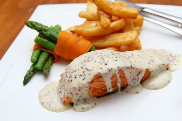 prato de comida pescetariana com uma fatia de salmão grelhada com legumes cozidos no vapor.
