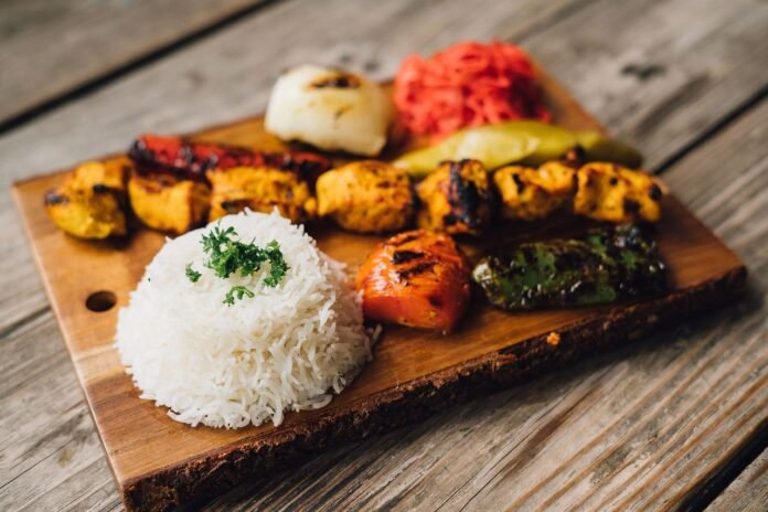 tabua de comida mediterrânea com arroz e legumes grelhados.