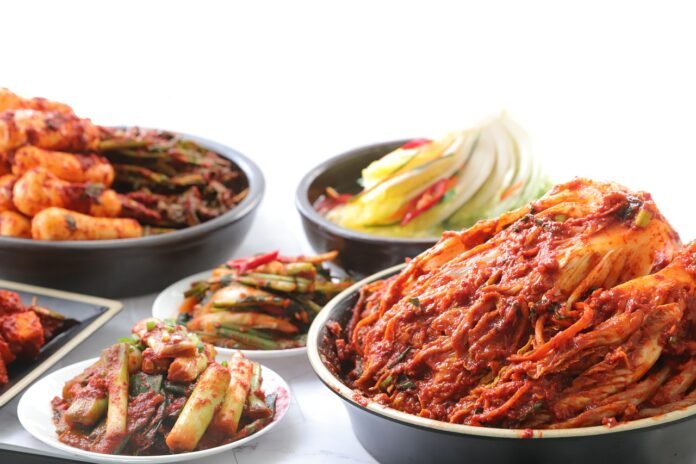 imagem com vários pratos contendo vários tipos de kimchi.