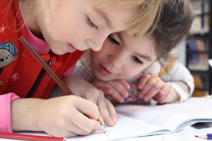 duas crianças desenhando.