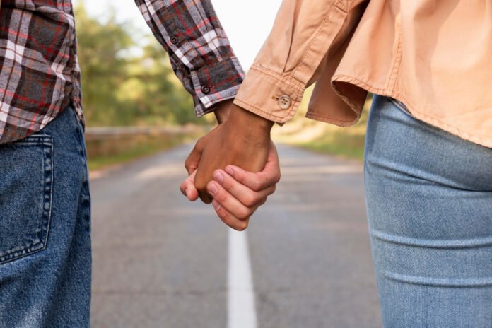 casal de mãos dadas em uma estrada.