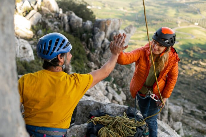 casal comemorando a conquista de uma escalada em uma montanha.