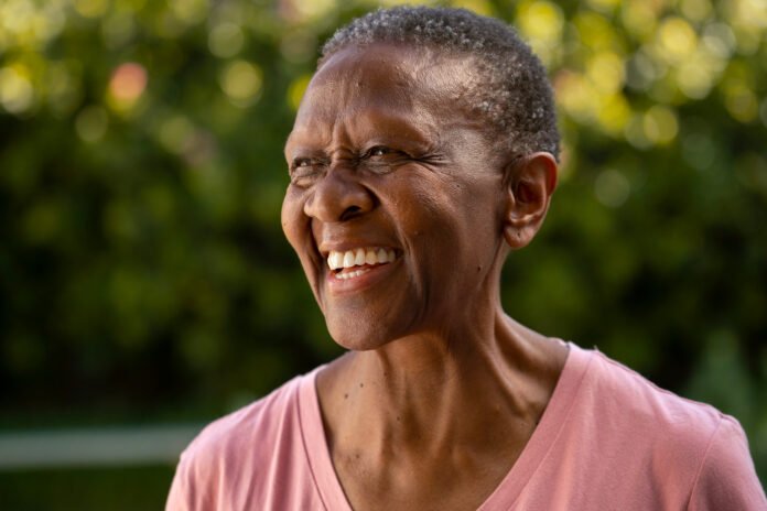 close de uma idosa negra sorrindo.