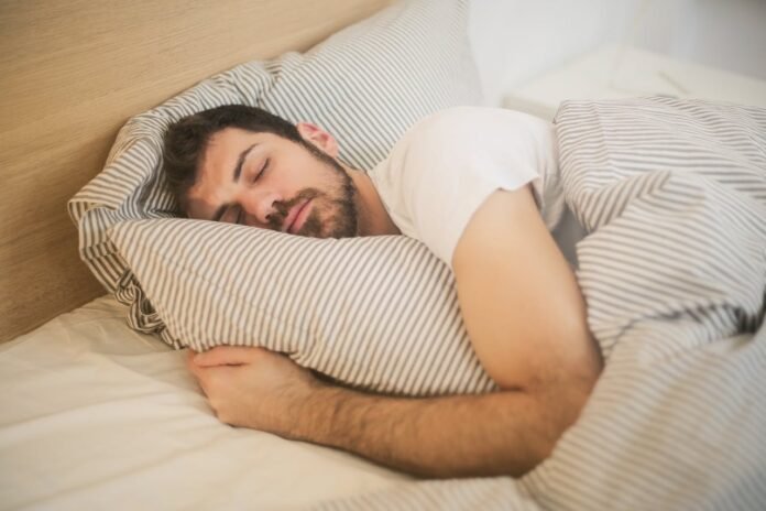 homem dormindo abraçado ao travesseiro.