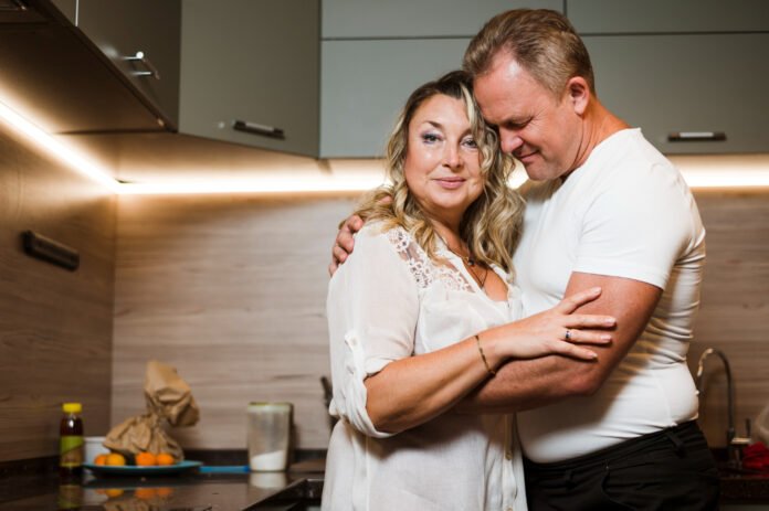 casal de meia idade abraçados.