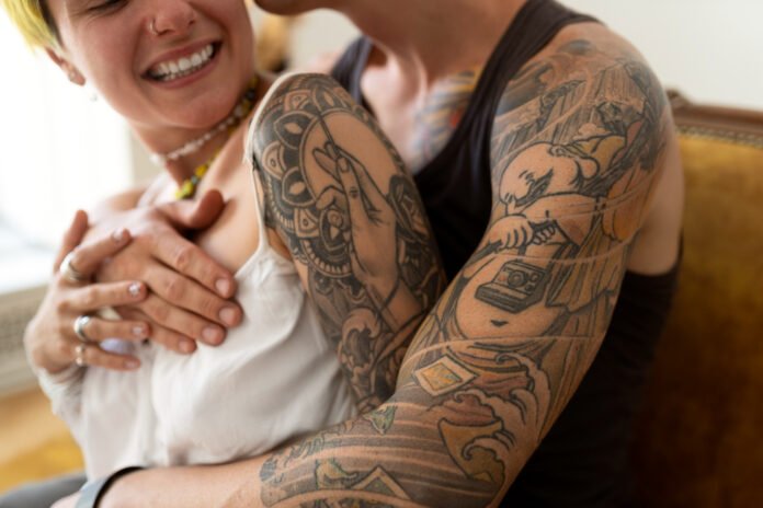 casal com varias tatuagens , abraçados.