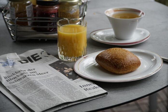 mesa de café da manha com suco de laranja e cafe.
