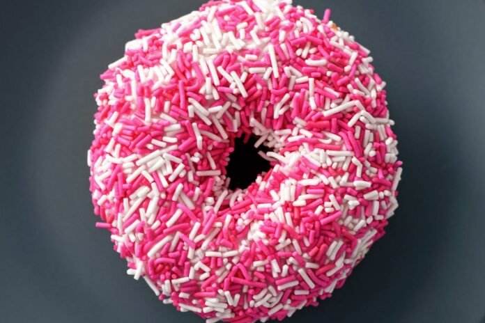 rosquinha doce com confeitos brancos e rosa.