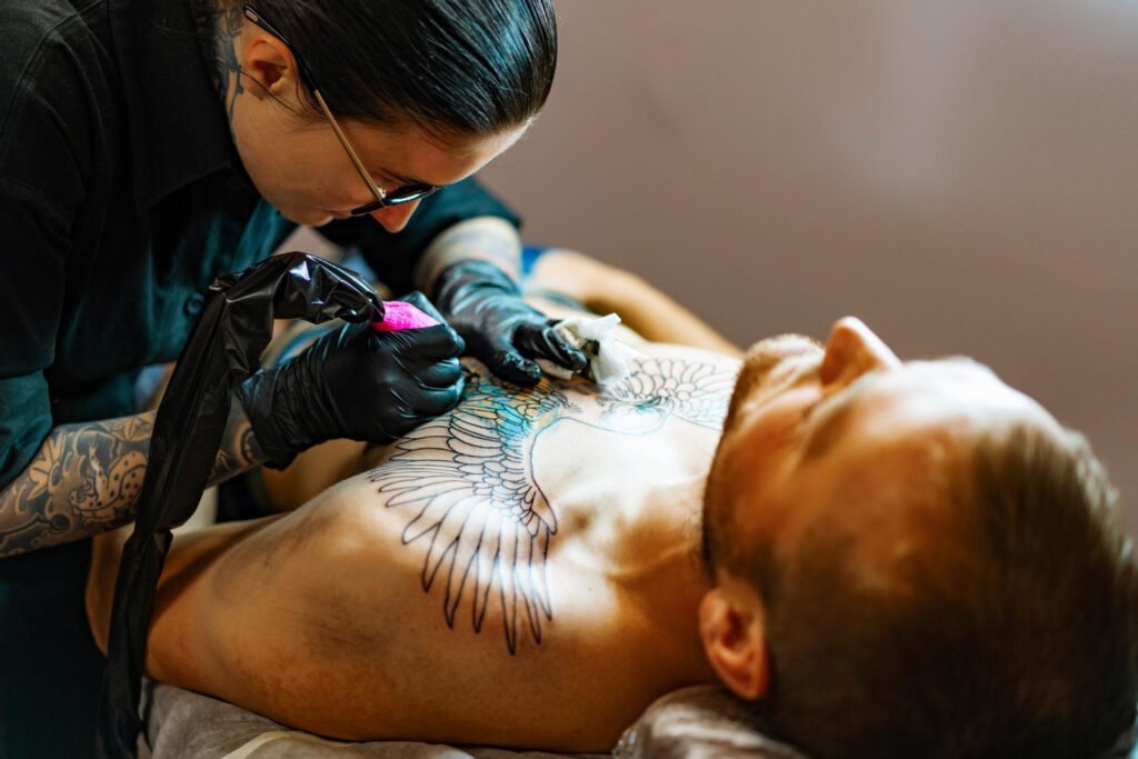 tatuadora tatuando o peito de um homem.