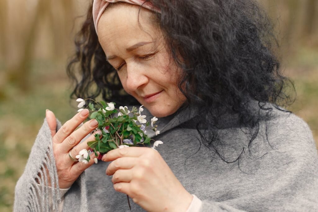mulher cheirando flores.