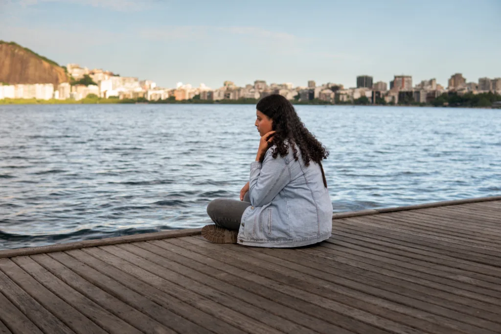 Mulher solitária  sentada num píer.